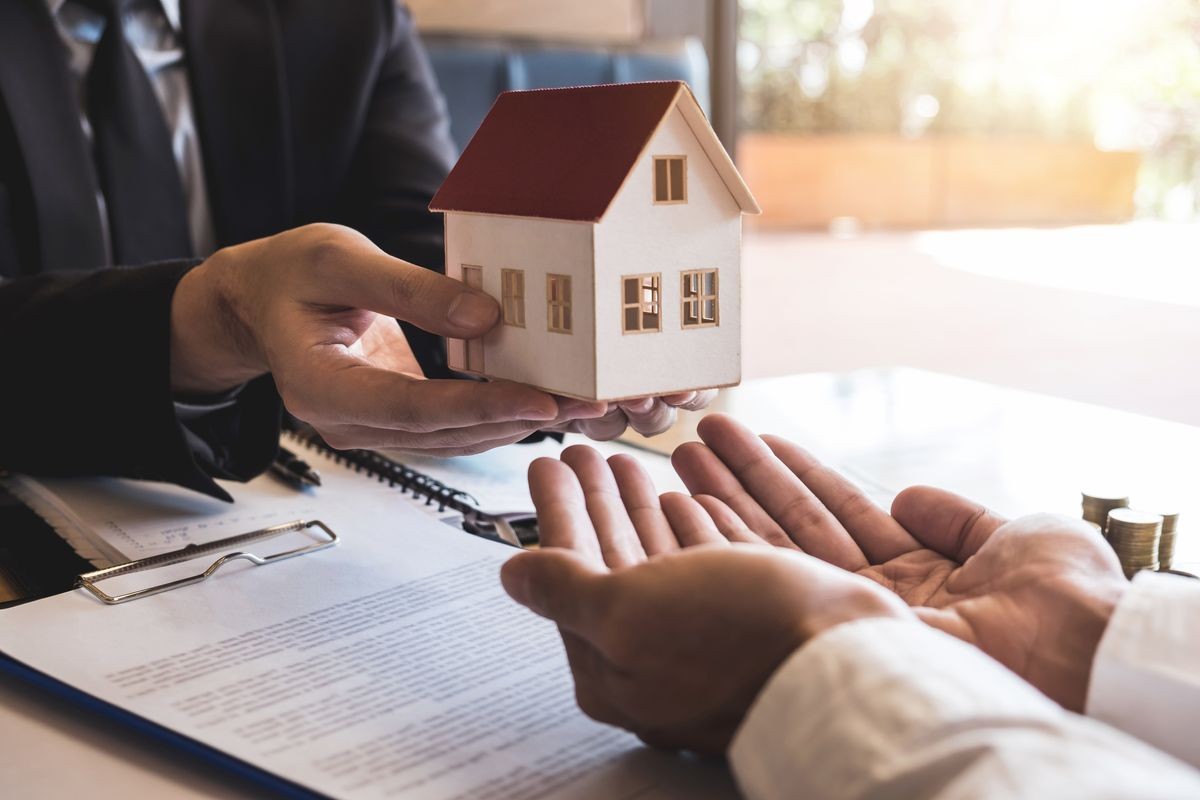 Estate agent sending house model to client after signing agreement contract real estate with approved mortgage application form, concerning mortgage loan offer for and house insurance.