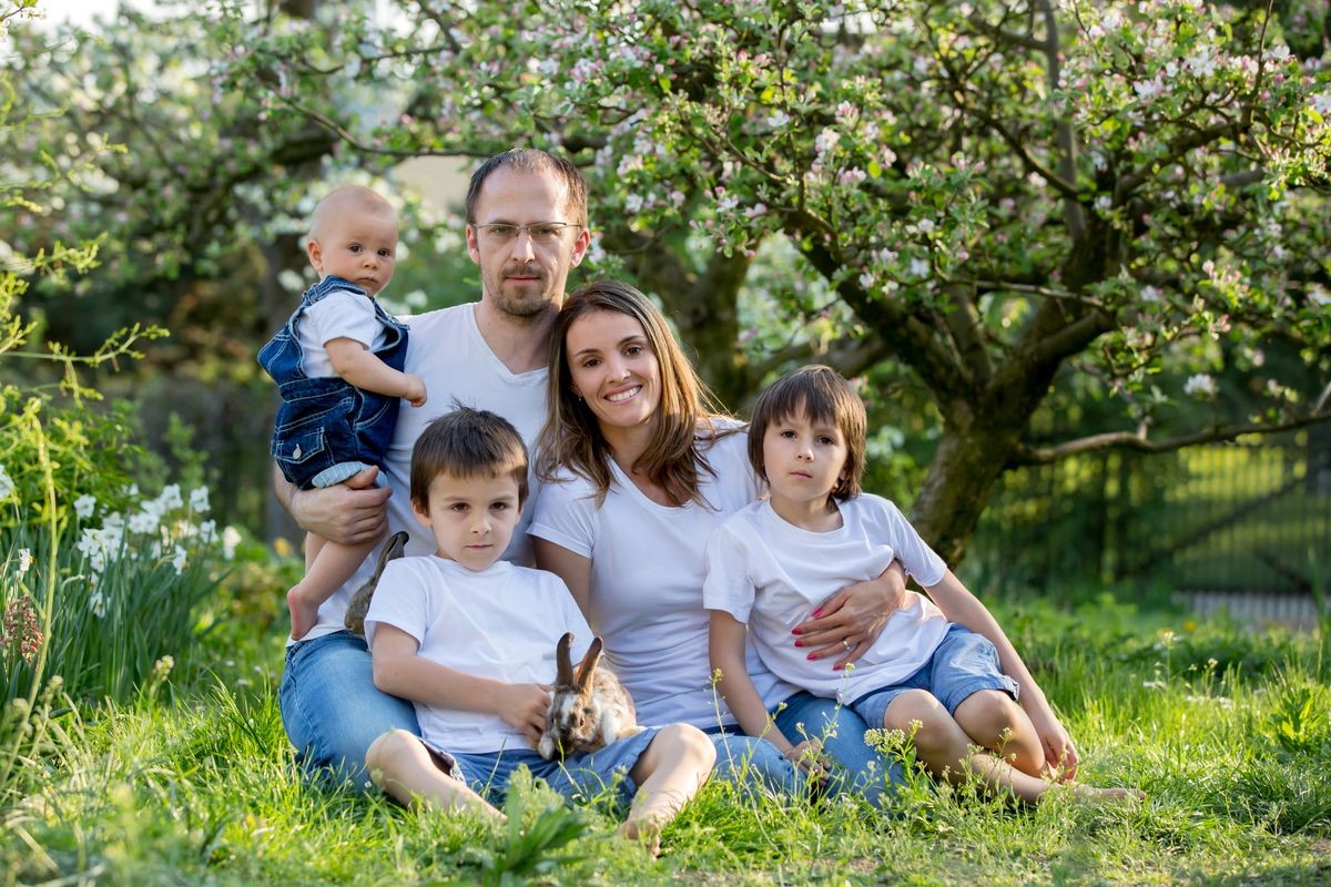 Fashionable big family, having their spring portrait taken with little bunnies, baby, preschoolers and patenrs